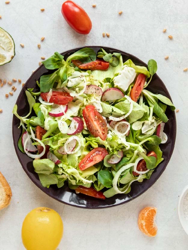 a plate of salad with tomatoes and lettuce